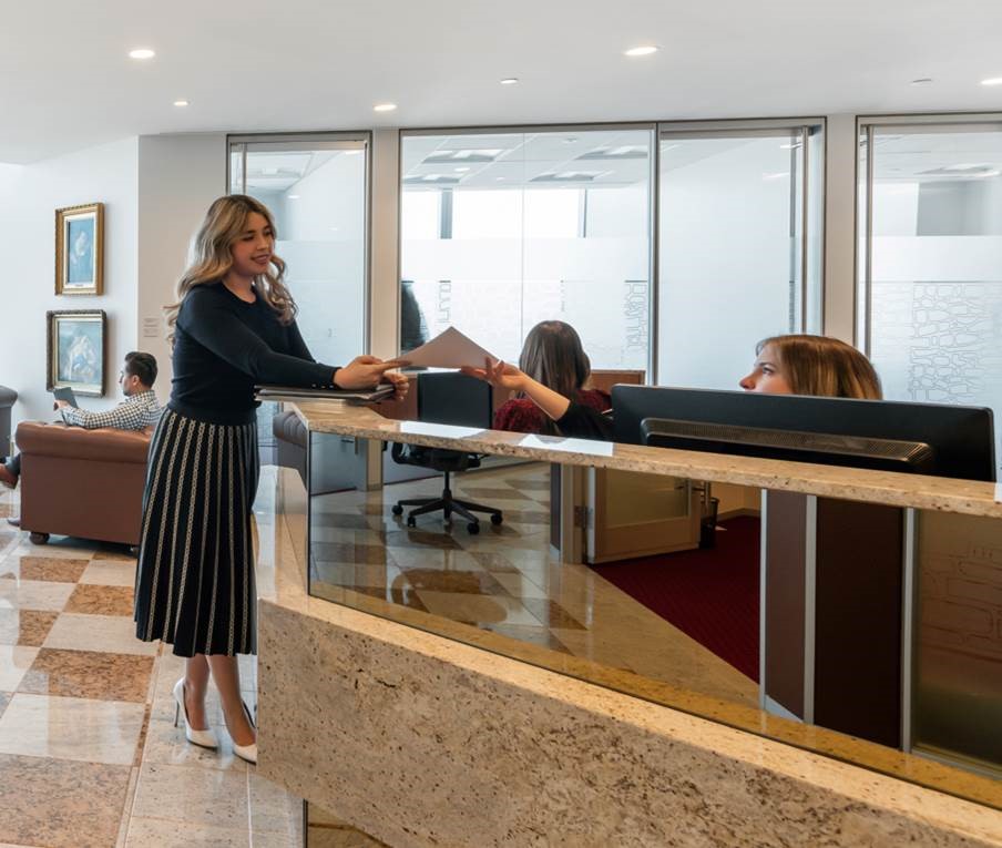 Premium coworking space at River Point, Chicago, where a client engages with the reception team for assistance.