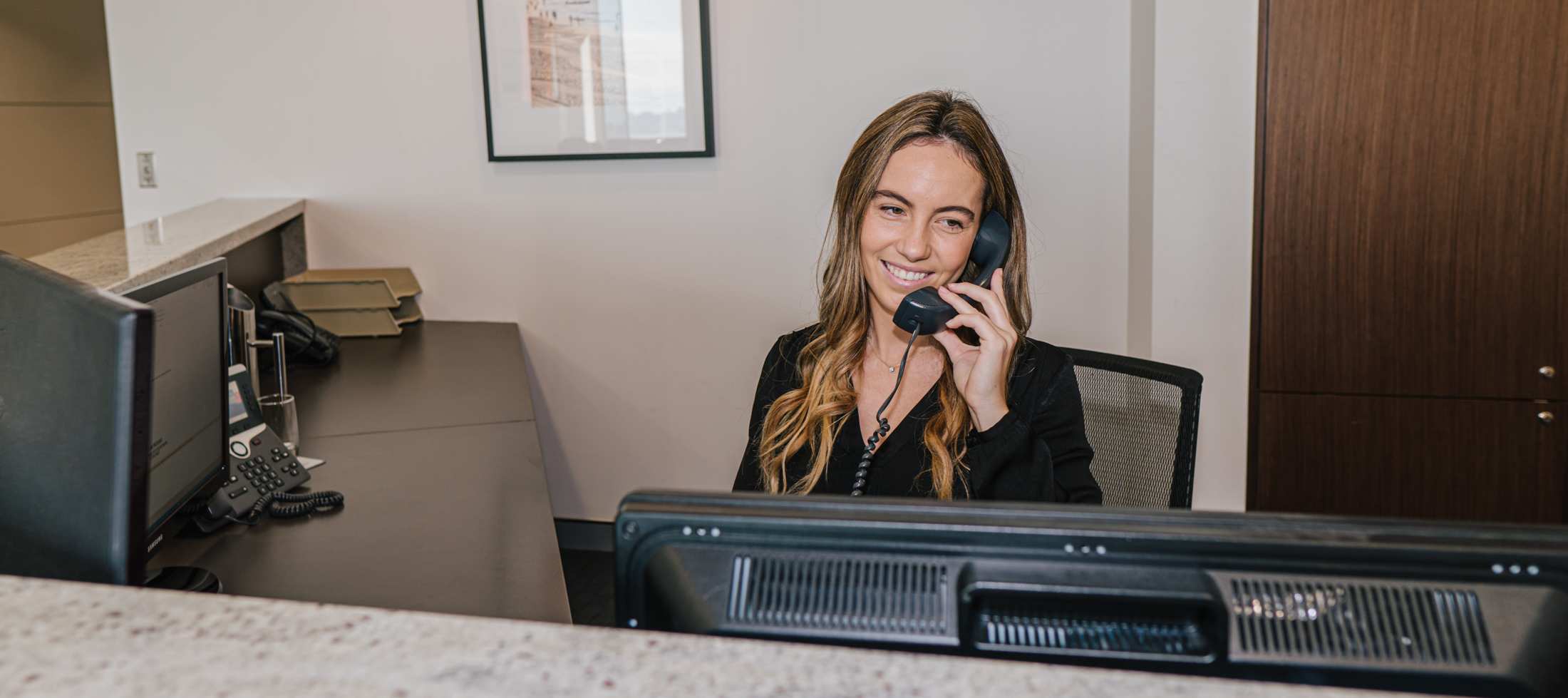  A receptionist answering calls at a professional front desk at Servcorp 