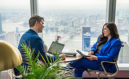 Professionals collaborate in a Servcorp corner office, enjoying natural light and breathtaking city views.