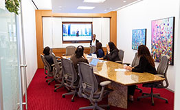 A team engages in a Servcorp meeting room presentation with modern tech, comfort, and executive style